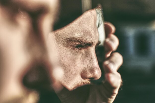 Close-up d'un homme tenant un miroir cassé à l'extérieur