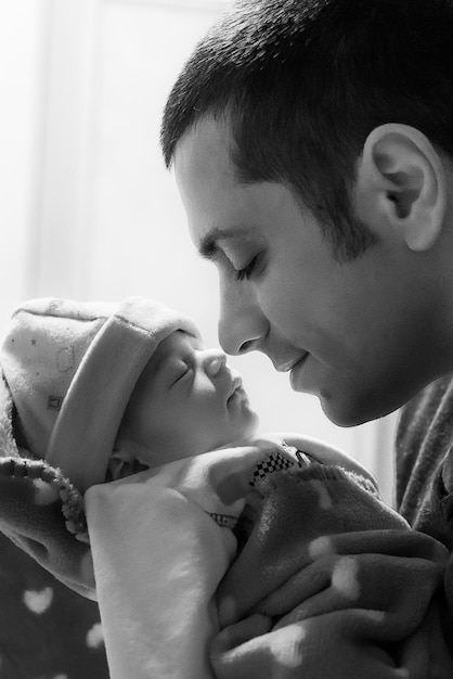 Close-up d'un homme touchant un bébé à la maison