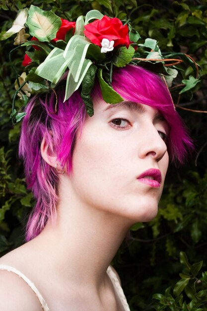 Photo close-up d'une jeune femme avec des fleurs et des cheveux roses