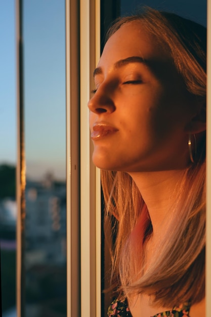 Photo close-up d'une jeune femme regardant par la fenêtre