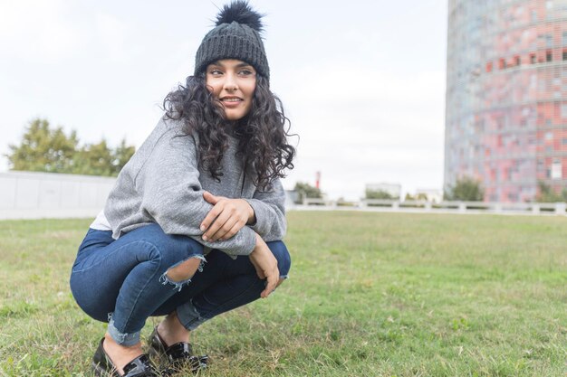 Close-up d'une jeune femme souriante accroupie sur le terrain