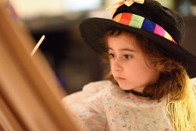 Close-up d'une jolie fille portant un chapeau en peignant