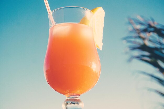 Photo close-up de jus d'orange dans un verre contre le ciel