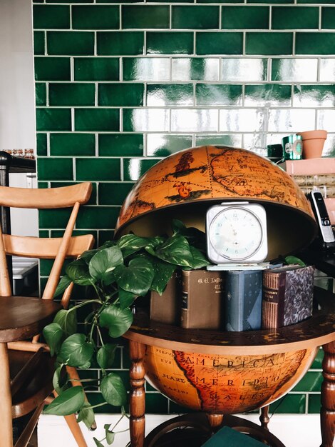 Close-up des livres et de l'horloge dans le globe modèle de table à la maison