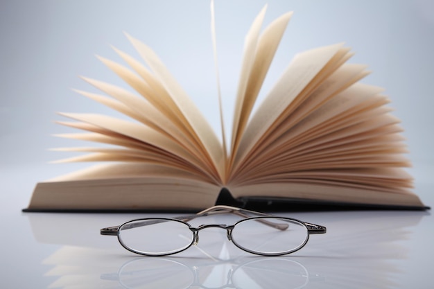 Close-up de lunettes et de livre sur fond blanc