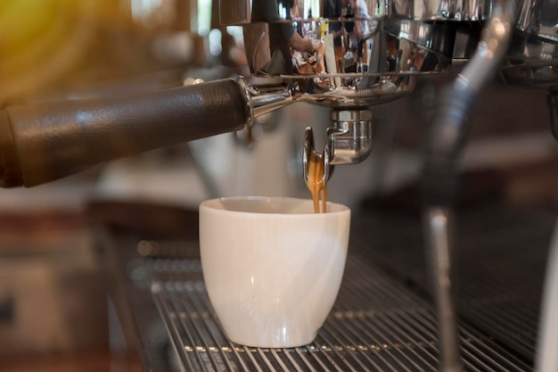 Close-up d'une machine versant du café dans une tasse