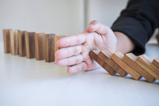 Close-up de la main d'une femme bloquant un bloc de bois sur un fond blanc