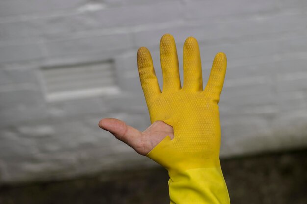 Photo close-up de la main gauche d'un homme portant un gant jaune cassé