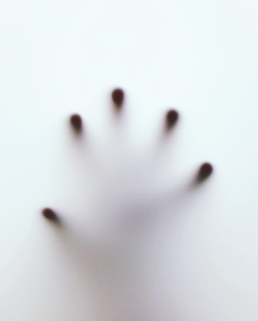 Close-up d'une main humaine sur une fenêtre condensée