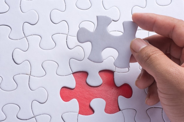 Close-up d'une main humaine tenant une pièce de puzzle