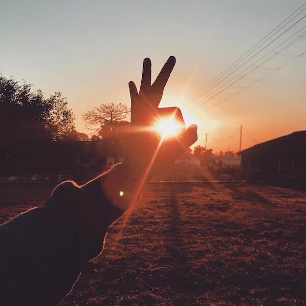 Photo close-up d'une main en silhouette contre le ciel au coucher du soleil