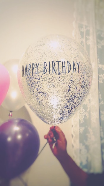 Close-up de la main tenant des ballons avec du texte