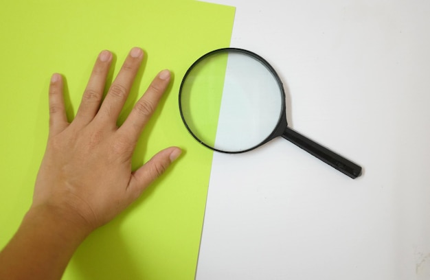 Photo close-up d'une main tenant du papier sur un fond blanc