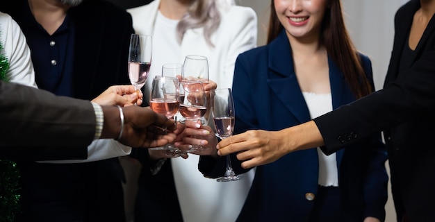 Photo close-up main tenant des verres les gens d'affaires célèbrent en faisant un toast à la fête de l'événement au bureau célébration concept de succès