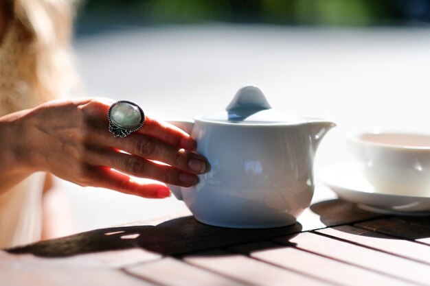 Photo close-up de mains féminines versant du thé dans une tasse