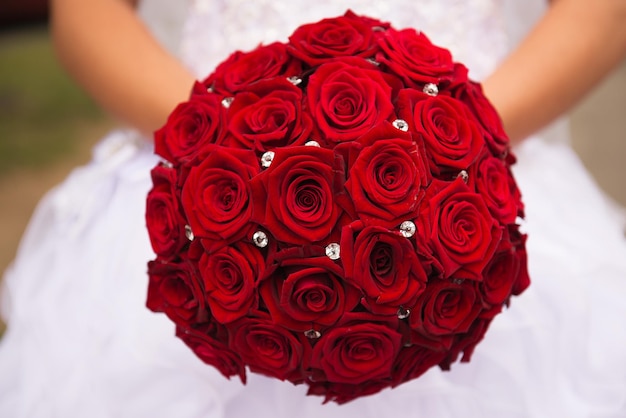 Close-up de mains tenant un bouquet de roses rouges