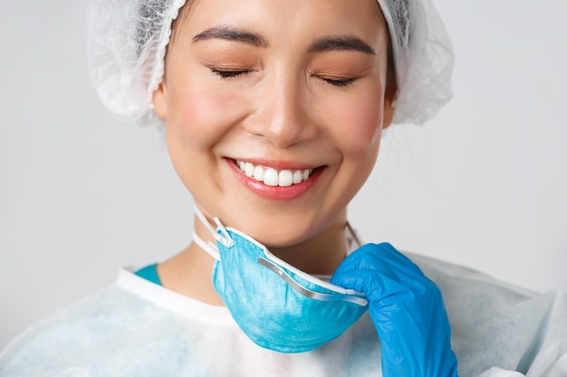 Close-up d'un médecin souriant tenant un masque