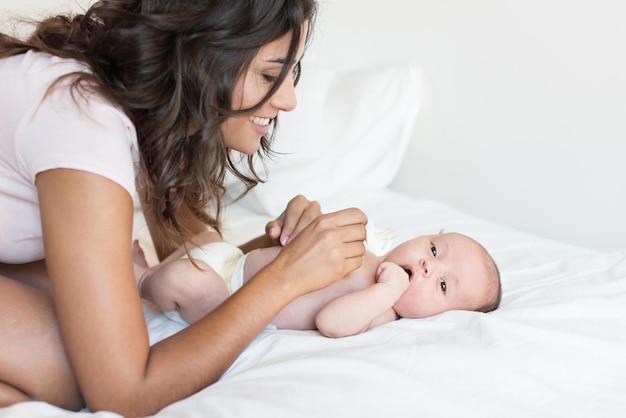 Photo close-up d'une mère jouant avec son fils sur le lit à la maison