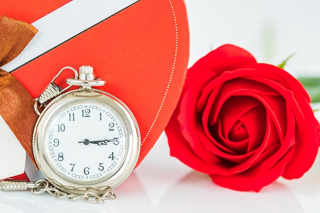 Close up montre de poche et fleur de roses rouges