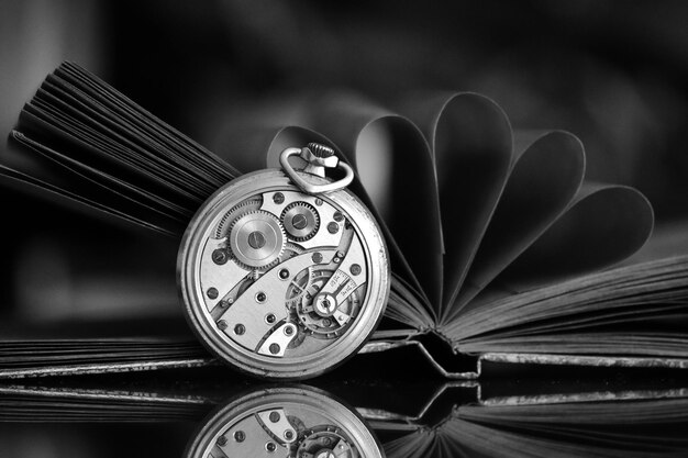 Photo close-up d'une montre de poche et d'un livre sur la table