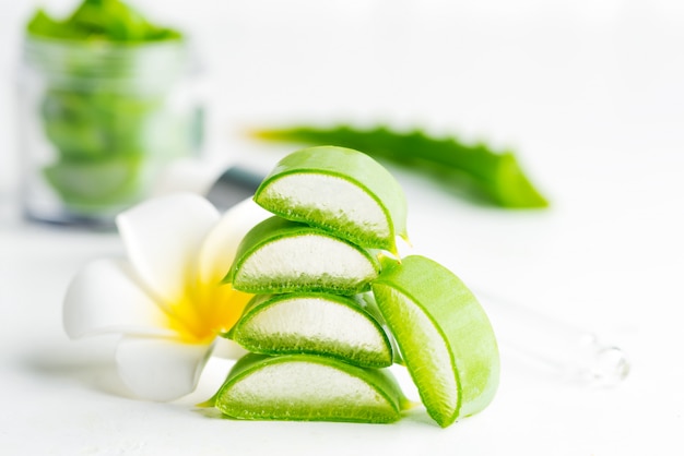 Close-up naturel d'aloe vera biologique en tranches pour liquide cosmétique fait maison contre du blanc.