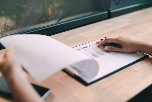 Photo close-up of businesswoman analyser le graphique au bureau - image