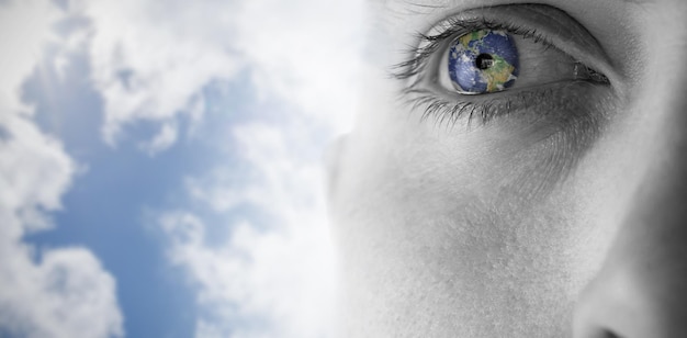 Close up of eye recherchant contre le ciel bleu lumineux avec des nuages