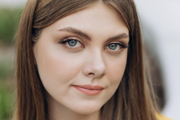 Close up of face young caucasian woman looking at camera sérieux attrayant beaux cheveux longs stan