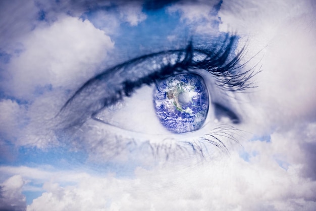Close up of female blue eye contre le ciel bleu avec des nuages blancs