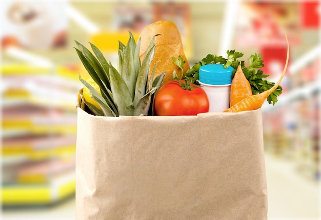 Close-up of fresh food in shopping bag on background