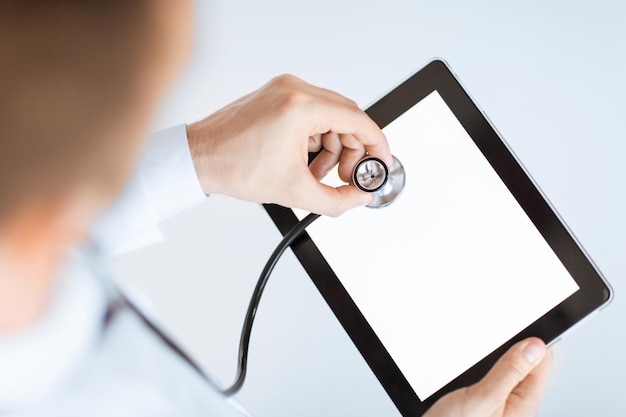 Close up of male doctor avec stéthoscope et tablet pc