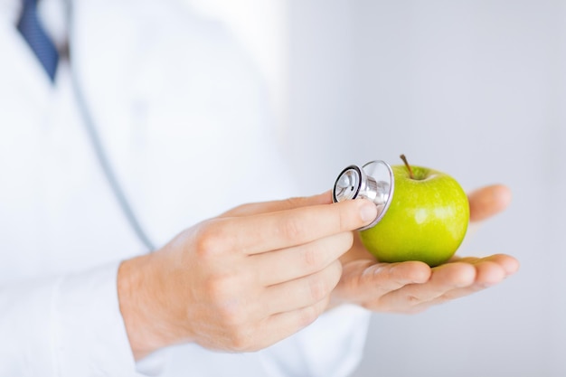 Close up of male doctor with green apple et stéthoscope