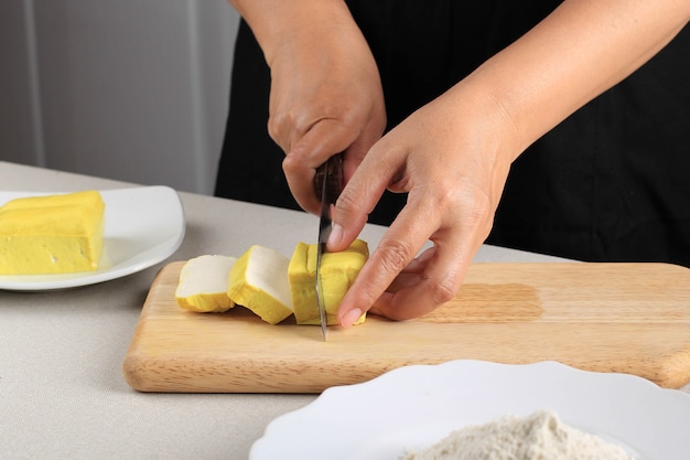 Close Up of Raw Bean Bandung Tofu Jaune Coupe en Cube avec couteau sur planche de bois