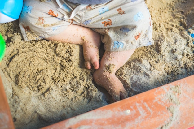 Close up of young baby boy jouant dans le bac à sable