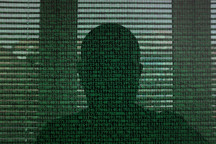 Photo close-up de l'ombre d'un homme sur des codes binaires