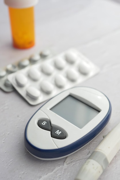 Close up d'outils de mesure du diabète et de pilules sur fond de couleur