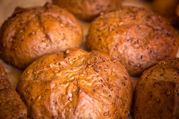 Close-up de pain blanc frais en petits pains se dresse en rangées égales dans une boulangerie