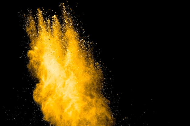 Close-up de peinture en poudre jaune éclaboussée sur fond noir