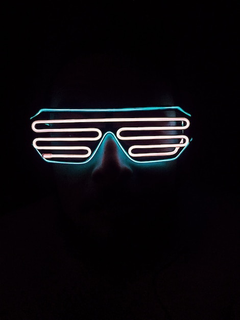 Close-up d'une personne portant des lunettes sur un fond noir