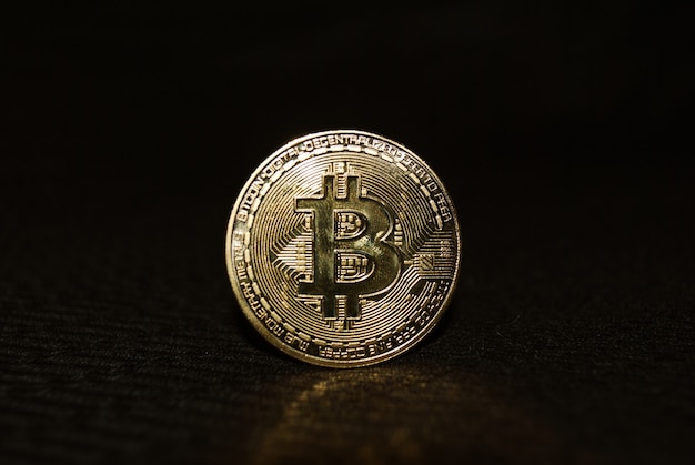 Close Up pièce d'or avec symbole bitcoin isolé sur fond sombre
