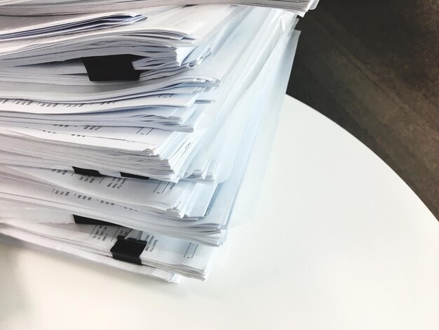 Photo close-up d'une pile de papiers sur le bureau au bureau