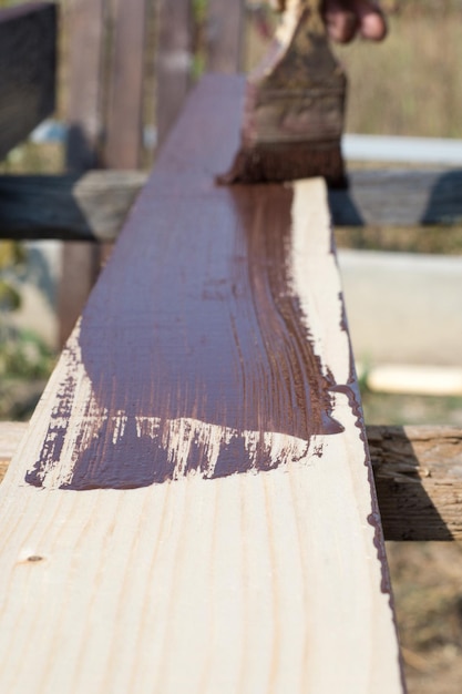 Close up pinceau à la main et peinture sur la table en bois