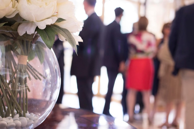 Photo close-up d'une plante en pot sur une table avec des gens en arrière-plan