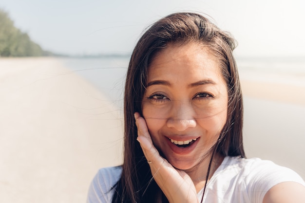 Close up portrait de femme en plein air sur la plage ensoleillée en été.