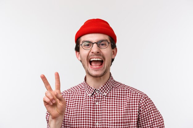 Close-up portrait gai et drôle homme barbu caucasien dans des verres et bonnet rouge