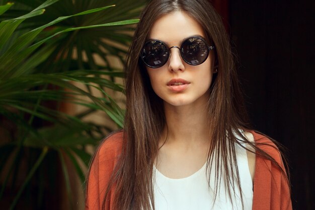 Close up portrait jeune fille en chemise blanche et lunettes de soleil