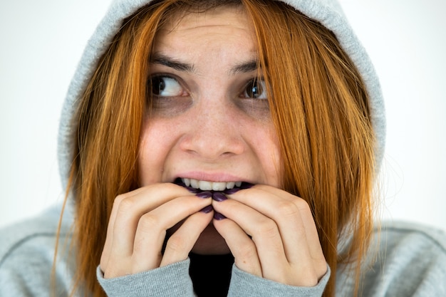 Photo close up portrait of effrayé jeune femme rousse portant un pull à capuche chaud