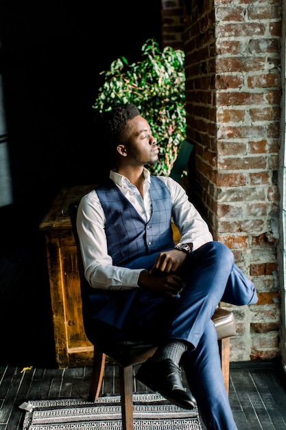 Close up portrait of handsome young male fashion model sitting by a window