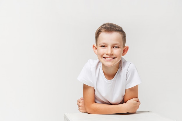 Close up portrait of young smiling cute teenager en blanc, isolé sur blanc