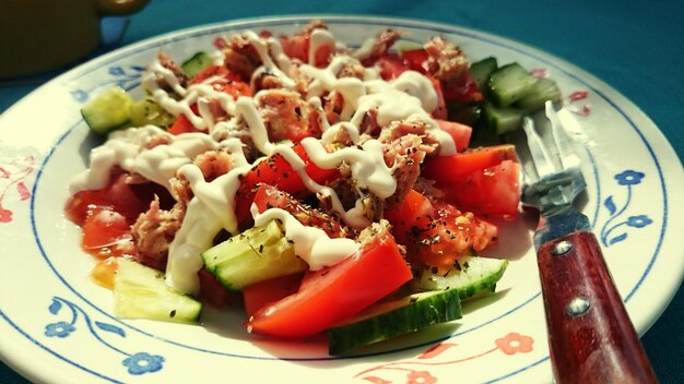 Close-up d'une salade avec du fromage et une fourchette dans l'assiette